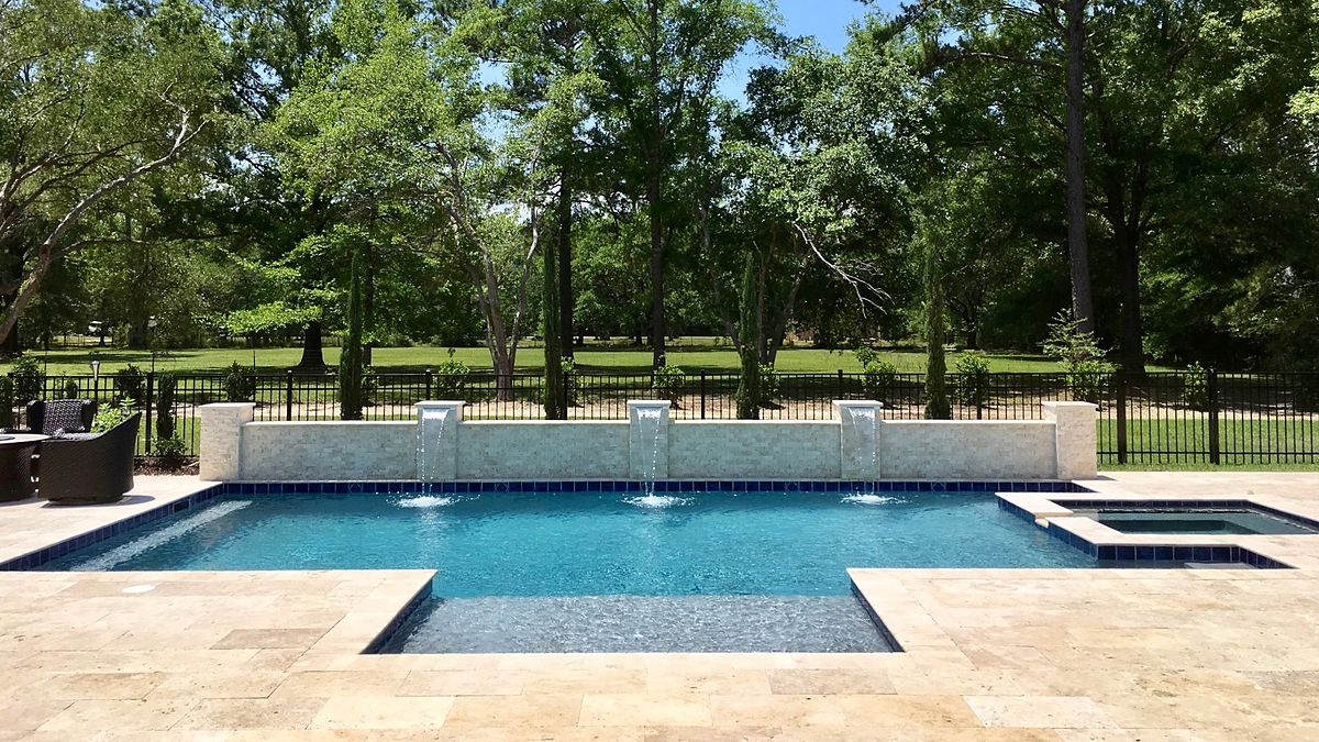 Custom gunite pool with a tanning ledge and sheer-descent waterfalls — pool builder in Covington, LA